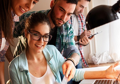 Group of young employees looking at work together